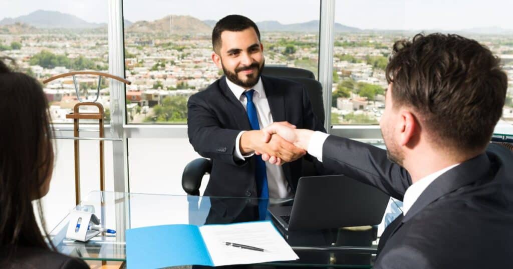 Two business professionals discussing leadership hiring strategies at an executive search firm.