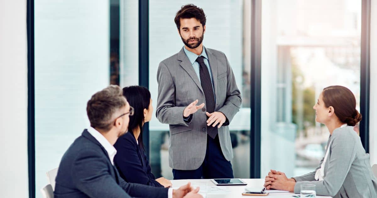 Senior executive leading C-Suite recruitment discussion with leadership team in office meeting