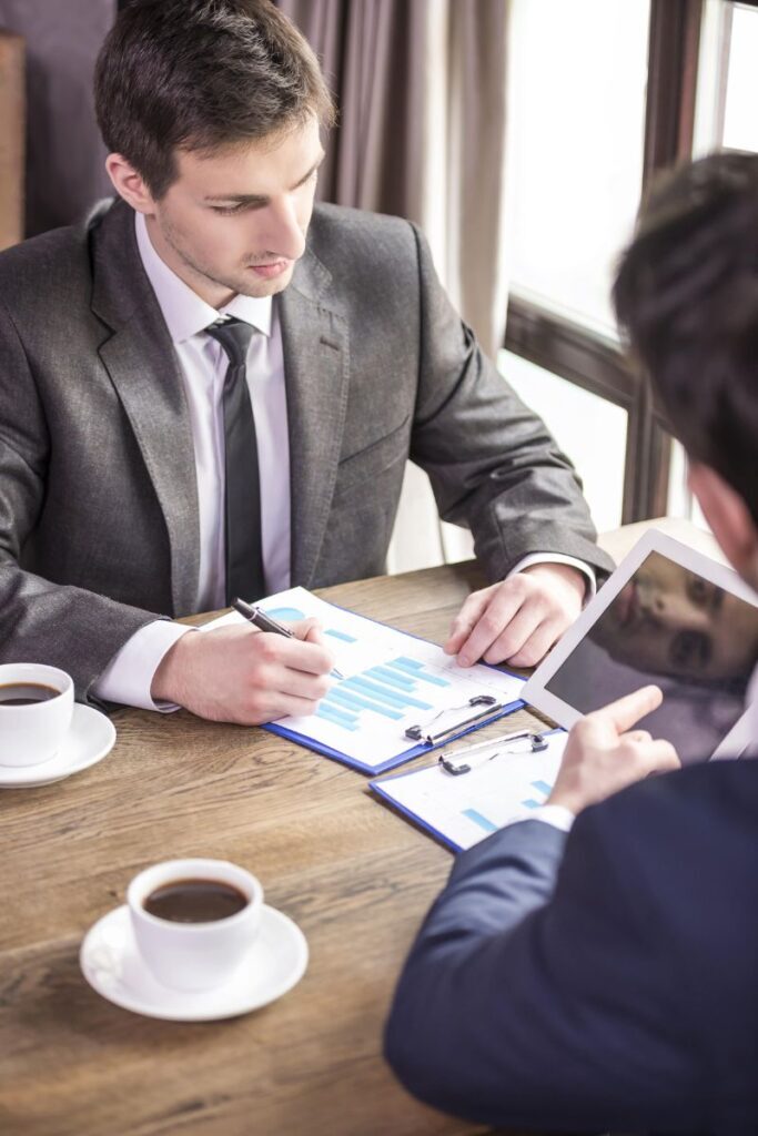 Professionals reviewing charts at a meeting with coffee, representing an executive search firm in Hyderabad.
