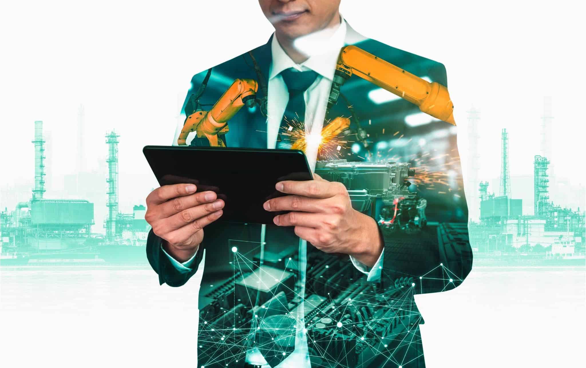Businessman using tablet with overlay of industrial automation and factory, symbolizing executive search