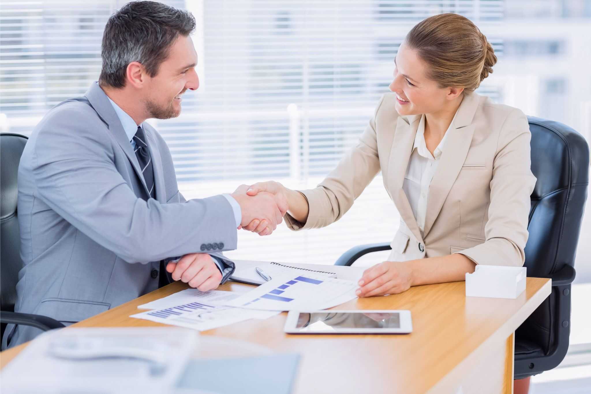Businessman and businesswoman shaking hands after finalizing financial executive hiring decision