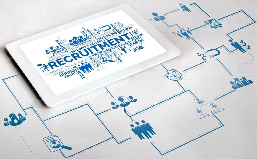 Businessman and businesswoman discussing data on a tablet at an executive search firm meeting.