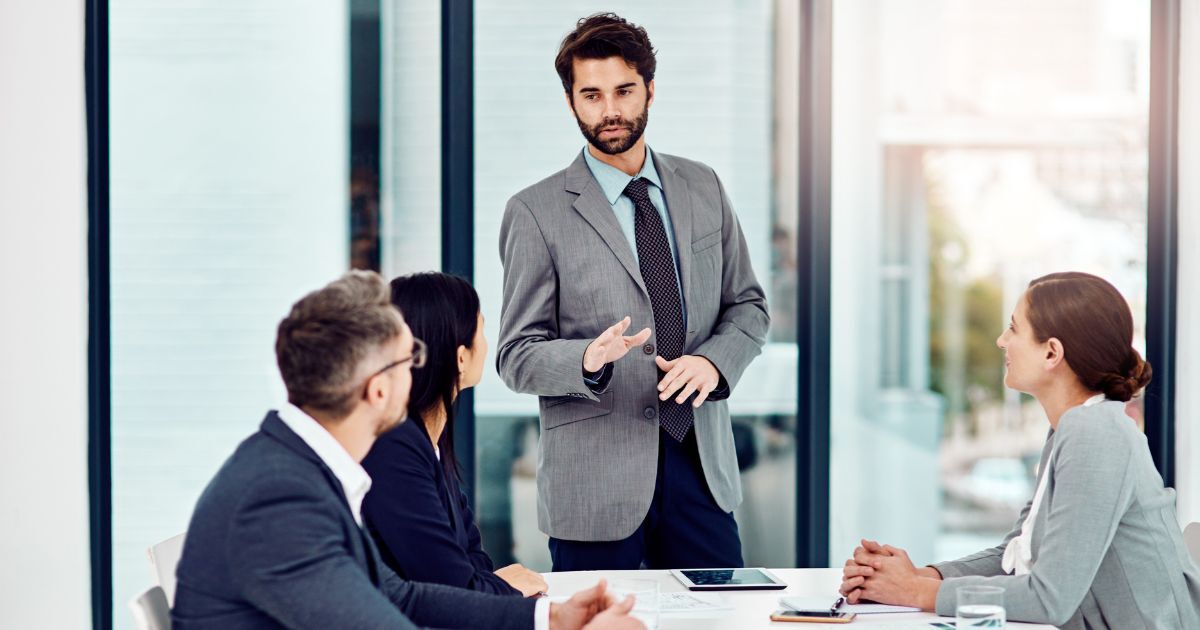 Senior executive leading C-Suite recruitment discussion with leadership team in office meeting