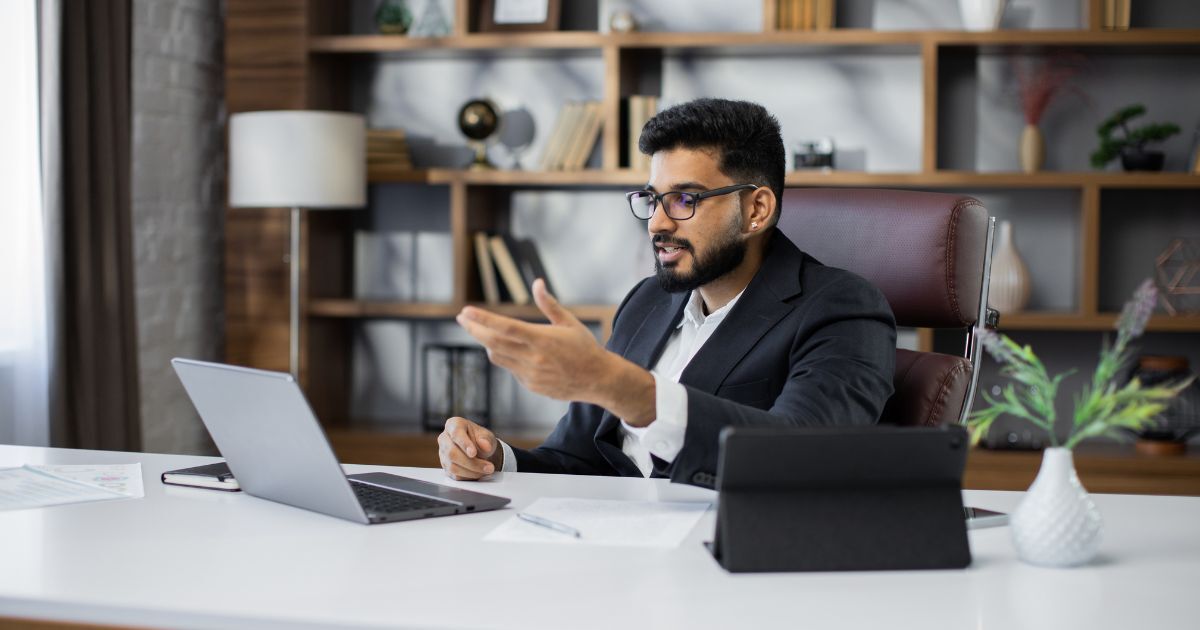 Executive discussing C-Suite recruitment strategy during virtual meeting in modern office setup