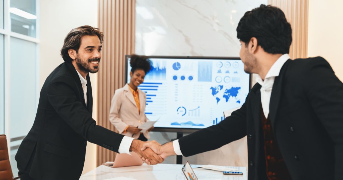 Strategic hiring partner handshake between business leaders in corporate meeting setting