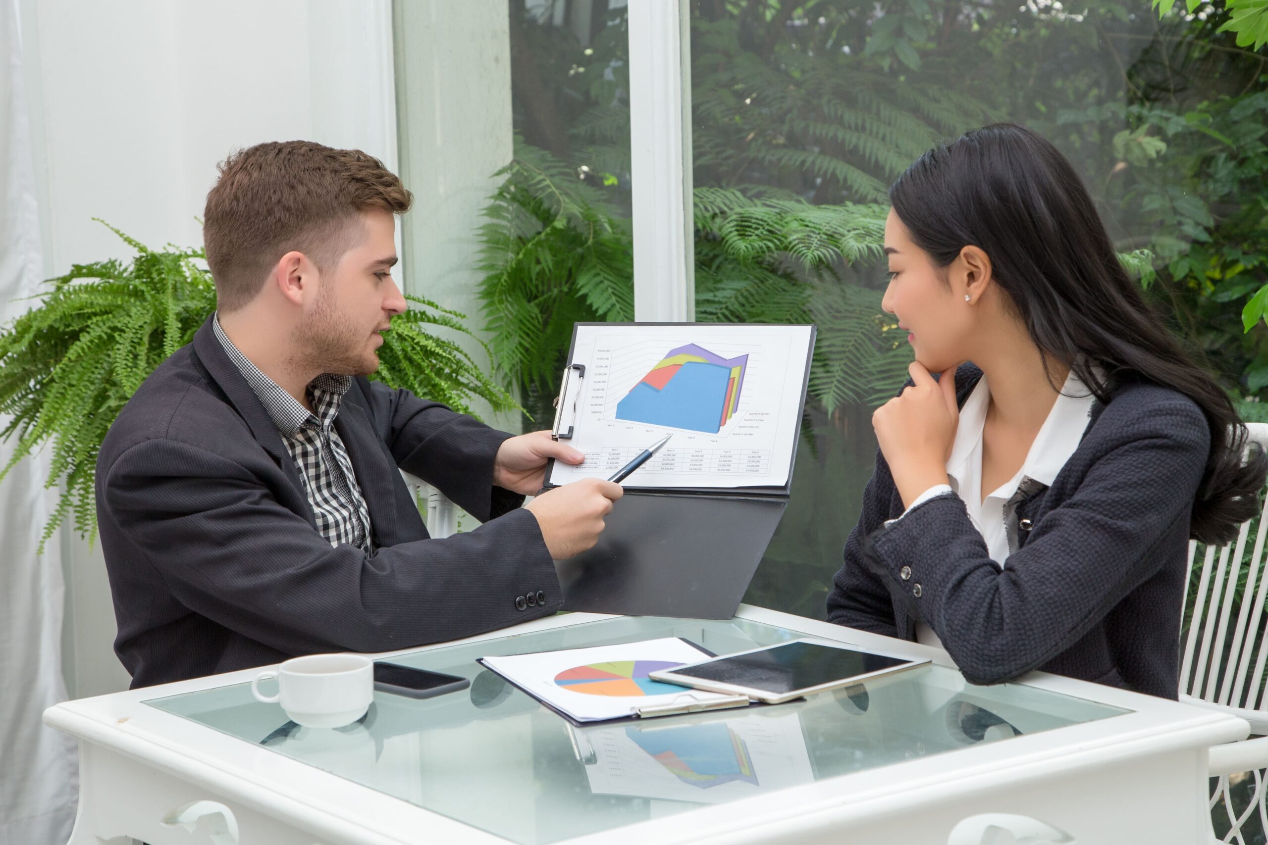 Professionals reviewing data charts for Technology Executive Search in a focused meeting with analytical tools.