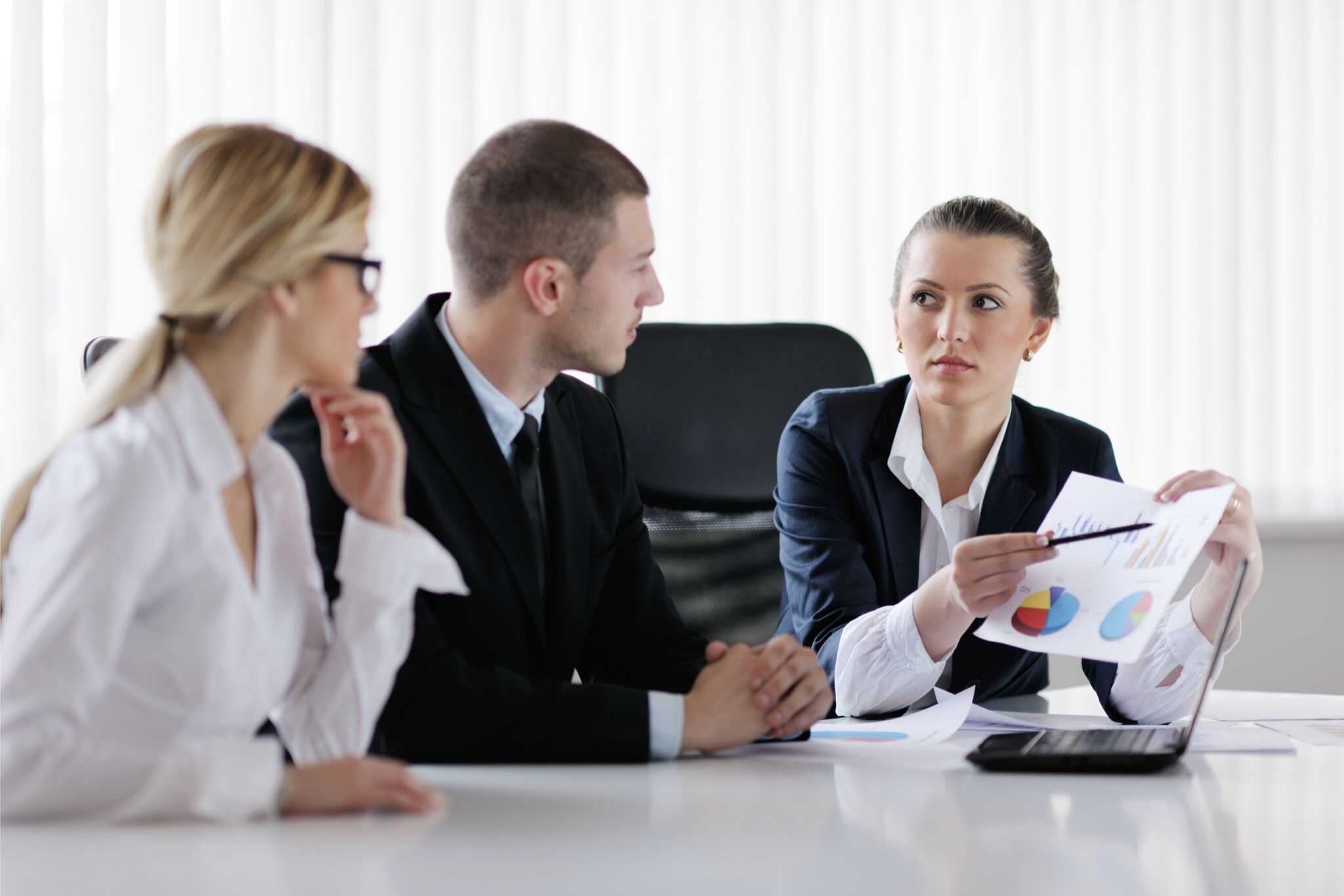 Business professionals in a meeting discussing executive charts and leadership recruitment strategies