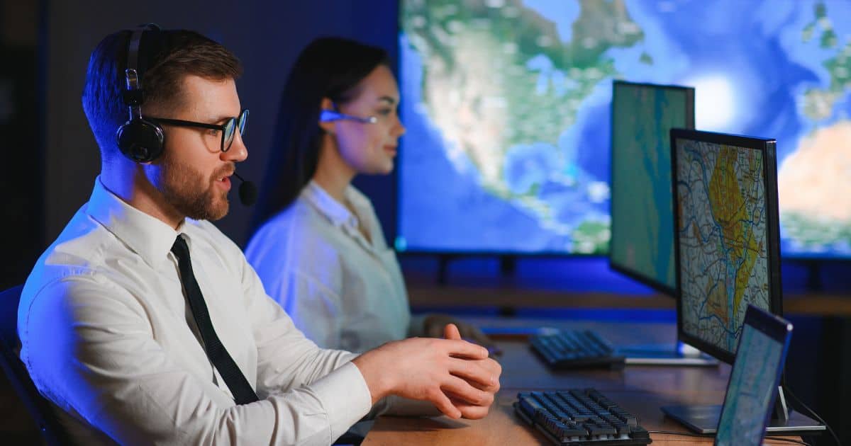 Two operations center staff, representing Telecom Executive Search Consultants working on global data maps.
