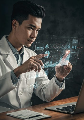 Professional in lab coat interacting with holographic data over laptop, symbolizing life science & healthcare executive search innovation.