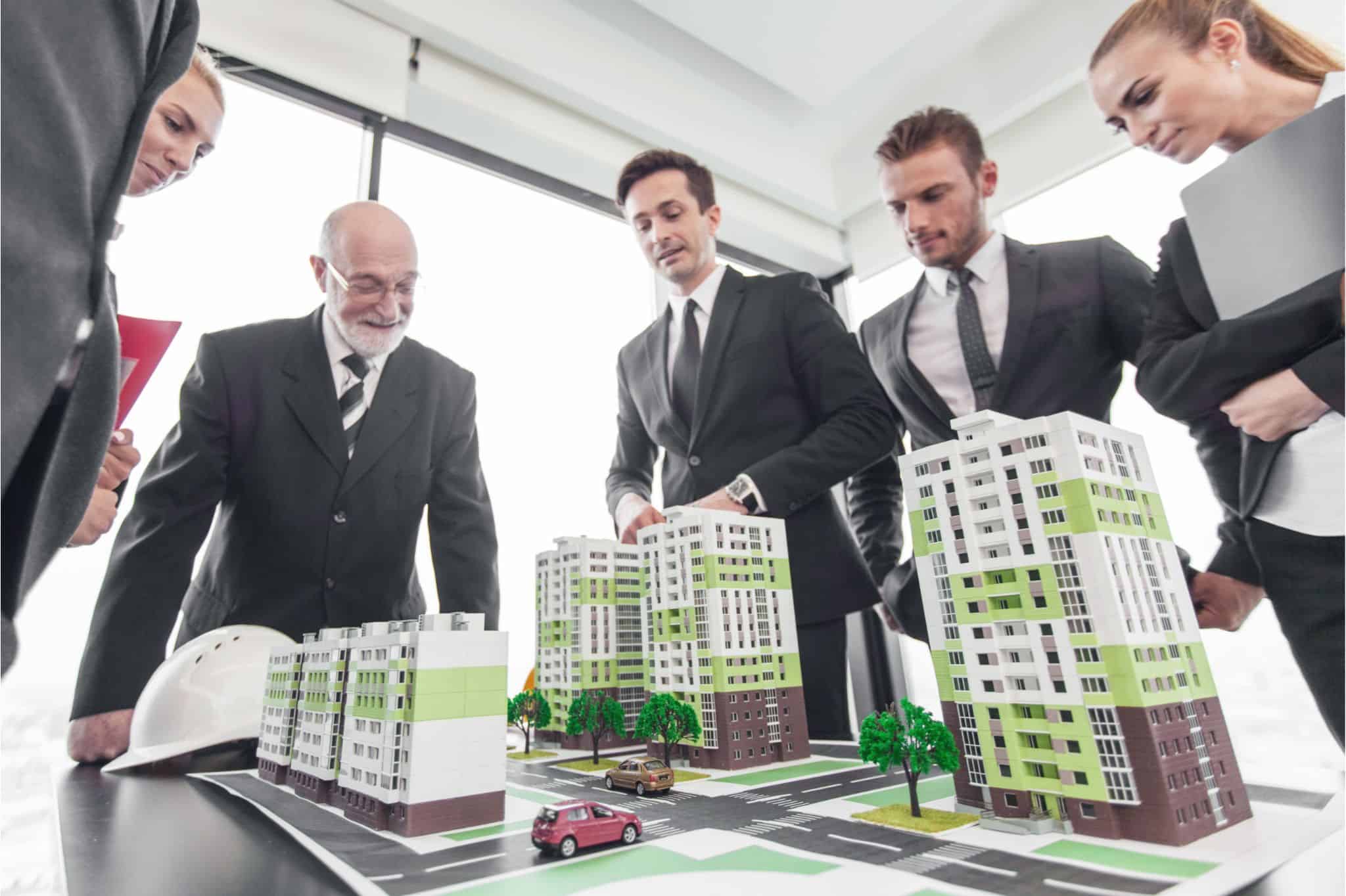 Executives analyzing a real estate and construction model, emphasizing executive search skills in a professional setting.